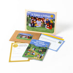 A photo of the It Takes a Village date night kit, showing the main envelope, a guide booklet, a smaller envelope with a sticker titled "refill kit," two Mayor cards, a letter card, and purple and yellow origami sheets.